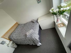 A bedroom with a bed, dresser and flowers at tbc 