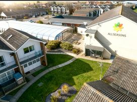 A view of a garden area with buildings at Pet-friendly villa with pool and sea views in Corton