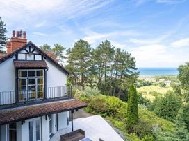 A house with a balcony and view of trees and sea at tbc in 