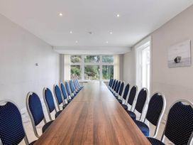 A conference room with a long table and chairs at tbc