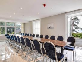 A conference room with a long table and chairs at tbc