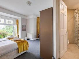 A bedroom with a bed and a door leading to a bathroom at tbc