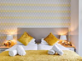 A bedroom with a bed, pillows, and lamps at tbc