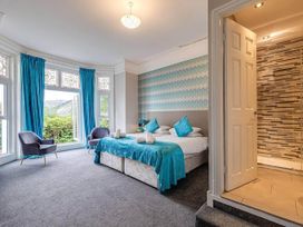 A bedroom with a bed and armchair at tbc 