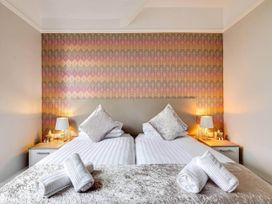 A bedroom with two beds and bedside lamps at tbc 