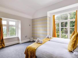 A bedroom with a bed and large windows at tbc in 