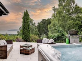 A patio with a hot tub and outdoor seating at tbc