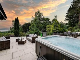 A garden with a hot tub and outdoor seating at tbc