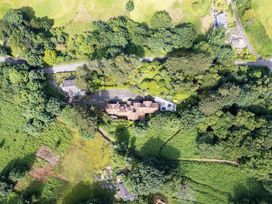 An aerial view of a house surrounded by trees and a road at tbc