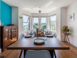 A dining room featuring a wooden table set with plates and glasses at tbc