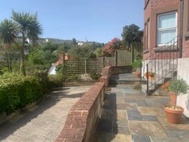 An outdoor garden with a stone pathway and flower pots at tbc 