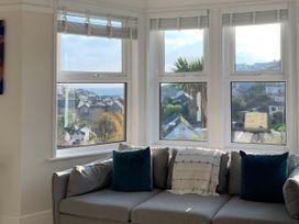 A living room with a sofa and windows showcasing a view at tbc in 