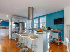 A kitchen with a cooking island and stools at tbc in 