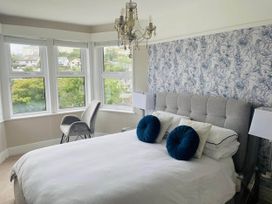 A bedroom with a bed and armchair at tbc