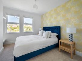 A bedroom with a bed and bedside table at tbc