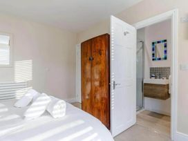 A bedroom with a bed and wardrobe leading to a bathroom at tbc