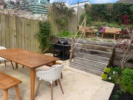 A garden with a dining table and chairs and a barbecue grill at tbc
