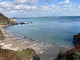 A beach with rocks and cliffs overlooking the sea at tbc