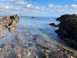 A coastal scene with rocks and calm water at tbc in 