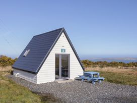 A cabin with a picnic table in front at Cabin 3 Cnoc na Naomh in Gortahawk