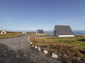 Four cabins with a gravel path and ocean view at Cabin 3 Cnoc na Naomh in Gortahawk