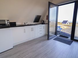 A kitchen with a microwave and kettle at Cabin 3 Cnoc na Naomh in Gortahawk