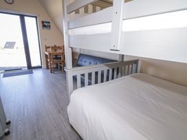 A bedroom with bunk bed and dining table at Cabin 3 Cnoc na Naomh in Gortahawk