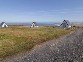An outdoor area with cabins and a view of the sea at Cabin 3 Cnoc na Naomh in Gortahawk
