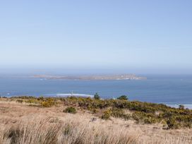 A view of an island in the ocean with grass in the foreground at Cabin 3 Cnoc na Naomh Gortahawk