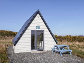 A cabin with a table and chairs outside at Cabin 4 Doire Chonair in Gortahawk