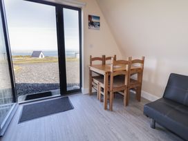 A dining area with a table and chairs at Cabin 5 Eargail Gortahawk