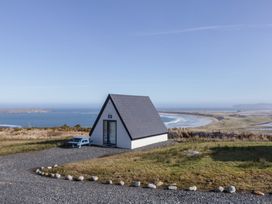 A cabin overlooking a lake and sea at Cabin 6 An Mhucais in Gortahawk