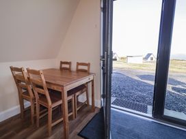 A dining area with a table and chairs at Cabin 6 An Mhucais in Gortahawk