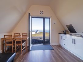 A kitchen with table and chairs at Cabin 6 An Mhucais in Gortahawk