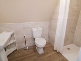 A bathroom with a toilet, sink, and shower at Cabin 6 An Mhucais in Gortahawk