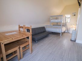 A bedroom with a bunk bed and a sofa at Cabin 9 Inish Beag in Gortahawk