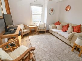 A living room with a sofa and television at St. Dominic Cottage in St. Ives