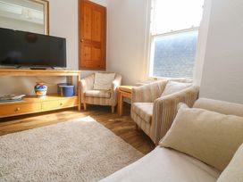 A living room with a television and two chairs at St. Dominic Cottage in St. Ives