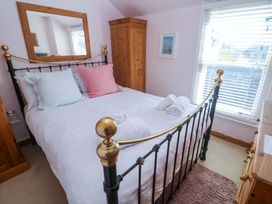A bedroom with a bed and wardrobe at St. Dominic Cottage in St. Ives
