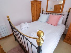 A bedroom with a bed and wardrobe at St. Dominic Cottage St. Ives
