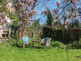 A garden with chairs and a table at Upper Frogpool Cottage in Crediton