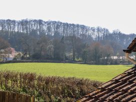 A field with trees and a house at Upper Frogpool Cottage in Crediton