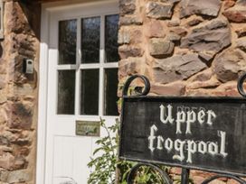 An entrance with a stone wall and door at Upper Frogpool Cottage in Crediton