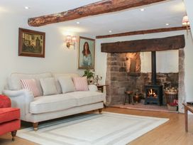 A living room with a sofa and fireplace at Upper Frogpool Cottage in Crediton