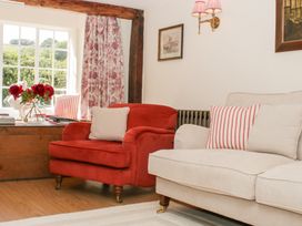 A living room with an armchair and a sofa at Upper Frogpool Cottage in Crediton