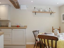 A kitchen with cabinets and a table at Upper Frogpool Cottage in Crediton