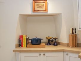 A kitchen area with a pot, scale, and books at Upper Frogpool Cottage in Crediton