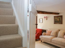 A living room with a staircase and seating at Upper Frogpool Cottage in Crediton