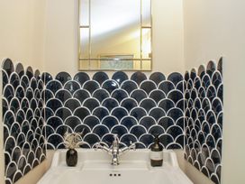 A sink with faucet and decorative tiles at Upper Frogpool Cottage in Crediton