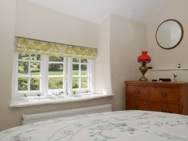 A bedroom with a window and a dresser at Upper Frogpool Cottage in Crediton